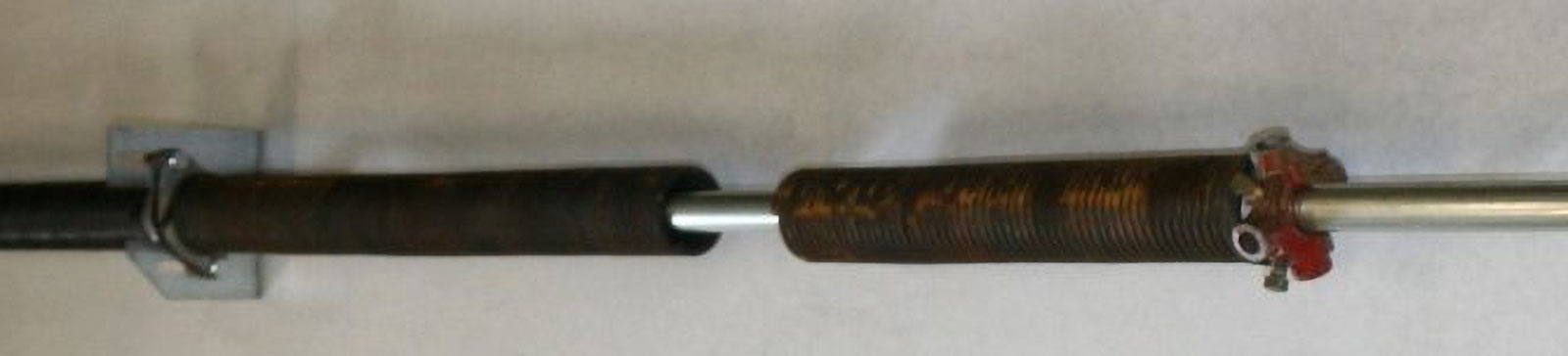 Close-up of broken garage door torsion spring before repair in Shakopee