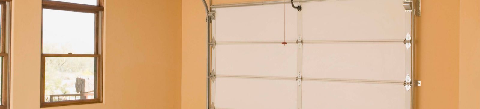 Clean residential garage with new white overhead door and automatic opener installed in Minnesota