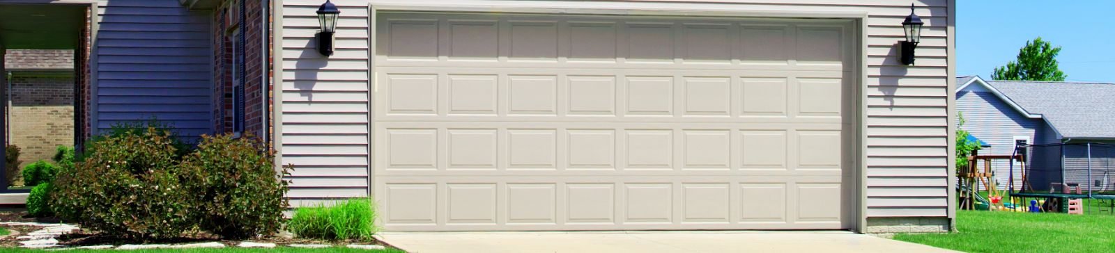 Front view of a modern beige double garage door on a Minnesota home, ready for repair or installation service