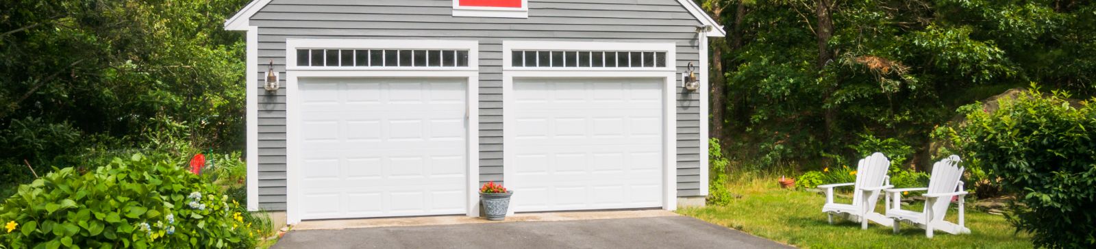 Modern gray garage with two white overhead doors and green yard in Shakopee, Minnesota